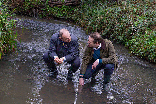 Tom Morrison and Ed Davey in a river in Carr Wood