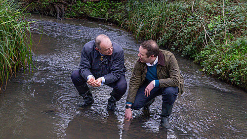 Tom Morrison and Ed Davey in a river in Carr Wood